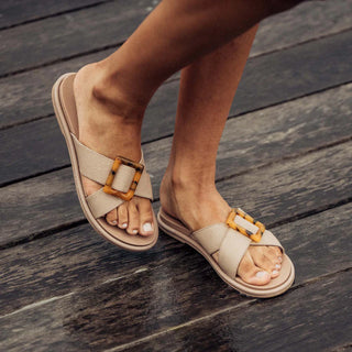 Olukai La'i Slide Women's Sandals in Taupe with tortoise shell buckle.