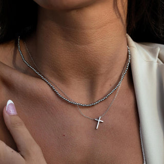 Silver cross necklace with minimalist pendant, stainless steel, hypoallergenic, and adjustable chain.