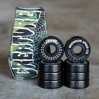 Bronson Speed Co X Creature Skateboards G3 bearings with spider web graphic and glow-in-the-dark coffin box.