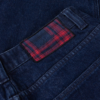 Indigo denim pants with flannel lining, distressing, and wavy pockets.