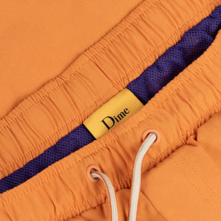 Dime MTL Secret Swim Shorts in Orange with water-reactive print and cursive logo embroidery.