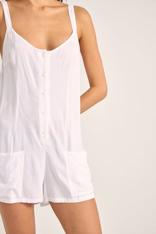 Rhythm Jayda Playsuit in white with adjustable straps, button detailing, and side pockets.