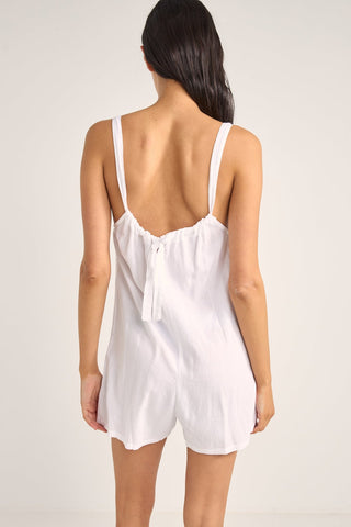 Rhythm Jayda Playsuit in white with adjustable straps, button detailing, and side pockets.