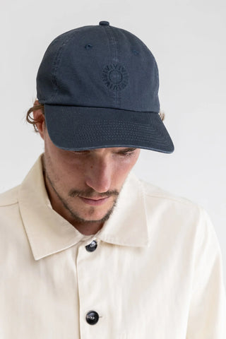 Vintage-style navy cap with sun logo embroidery and adjustable strap.