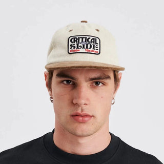 Ecru flat-brim cap with contrast brim and snapback closure.