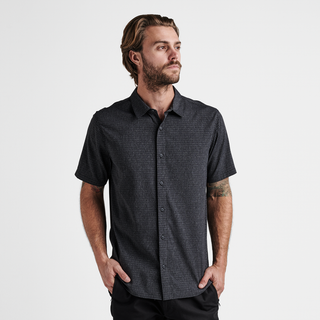 Roark Bless Up Shirt in black, lightweight perforated design, soft rubberized buttons, moisture-wicking Tactel™ fibers, short sleeve fit.