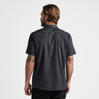 Roark Bless Up Shirt in black, lightweight perforated design, soft rubberized buttons, moisture-wicking Tactel™ fibers, short sleeve fit.