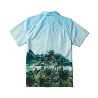 Model showcasing the Roark Gonzo Camp Collar Shirt - Hinano Otemanu Light Blue, a Tahiti-inspired piece made from an organic cotton and Tencel blend. This relaxed fit shirt embodies the serene beauty of Bora Bora's Otemanu peak.