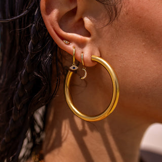 Gold hoop earrings with 18K plating, hypoallergenic, push-back clasp, and water-resistant.