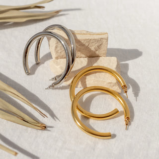 Gold hoop earrings with 18K plating, hypoallergenic, push-back clasp, and water-resistant.