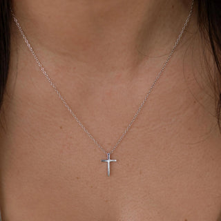 Silver cross necklace with minimalist pendant, stainless steel, hypoallergenic, and adjustable chain.