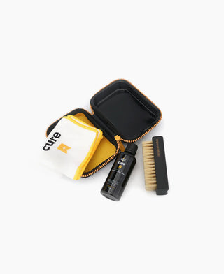 Crep Protect Cure Cleaning Kit with solution, brush, cloth, and case for effective sneaker maintenance.